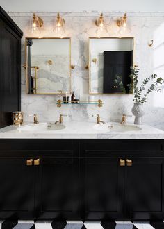 two sinks in a bathroom with marble counter tops and gold fixtures on the mirrors above them