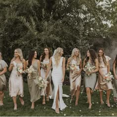 a group of women standing next to each other on top of a lush green field