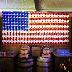 an american flag made out of beer bottles is displayed on a wall next to barrels