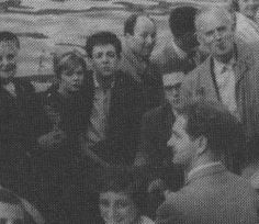 black and white photograph of people standing around each other