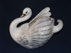 a white swan figurine sitting on top of a table