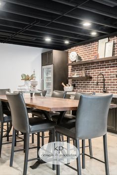 a dining room table with chairs and a brick wall in the back drop off area