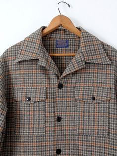 A 1960s vintage Pendleton plaid check wool coat. The men's jacket features a beige, gray, and orange plaid pattern. It has four pockets, and black button closures. • Pendleton Woolen Mills• pure virgin wool• gray, orange, and beige plaid• four pocket• black button closureCONDITIONIn good condition with wear consistent with age and use. MARKED SIZE: LMEASUREMENTSBust:  48"  ...  121.9 cmLength:  31"  ...  78.7 cmShoulders:  20"  ...  50.8 cmSleeves:  34"  ...  86.4 cmOuter Sleeve: 23.5"  ...  59. Plaid Wool Tweed Jacket With Patch Pockets, Plaid Wool Tweed Jacket With Pockets, Plaid Wool Button-up Outerwear, Retro Long-sleeved Tweed Outerwear, Vintage Button-up Tweed Jacket For Fall, Retro Plaid Tweed Jacket For Fall, Retro Long Sleeve Tweed Outerwear, Retro Tweed Outerwear, Classic Plaid Outerwear With Pockets