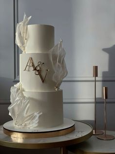 a three tiered white wedding cake on a table