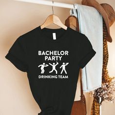 bachelor party drinking team t - shirt hanging on the wall next to a hat rack