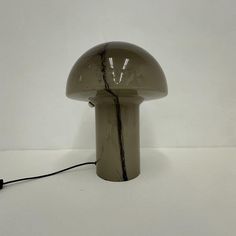 a mushroom shaped lamp with a cord attached to it