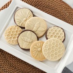 some cookies are on a white plate next to a brown and white checkered table cloth