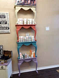 a shelf with many different items on it in a room next to a table and chair