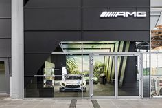 the entrance to an automobile showroom with cars parked in it's garage doors