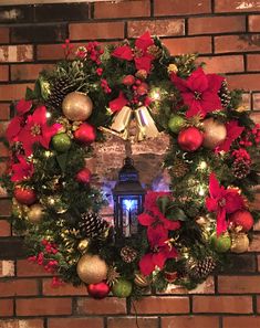 a christmas wreath on a brick wall with lights and poinsettis around it