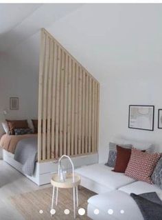 a living room filled with white furniture and lots of wood slats on the wall