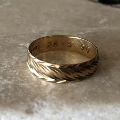 a close up of a gold ring on a white surface with the number twenty five