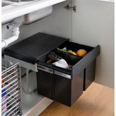 an open drawer on the side of a kitchen cabinet filled with food and drink items