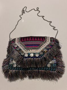 This Express Bohemian Women's Purse is sure to turn heads with its unique details. The rectangular shape is adorned with fringe, coins, beading, embroidery, and stitching, giving it a bohemian flair that is perfect for a variety of occasions. The snap closure keeps your belongings secure, while the chain strap in silver adds a touch of edgy elegance. There is an interior pocket. The bag measures 8.75” x 11.5”. This is a very cool purse that will turn heads! Bohemian Beaded Clutch For Festivals, Festival Party Bags With Tassels, Bohemian Beaded Festival Clutch, Bohemian Summer Festival Clutch, Party Bags With Tassels For Festivals, Bohemian Summer Clutch With Tassels, Bohemian Fringe Rectangular Clutch, Bohemian Fringe Clutch For Summer, Bohemian Rectangular Clutch For Festival