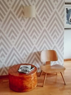 a chair and table in front of a wall with an interesting pattern on the wall