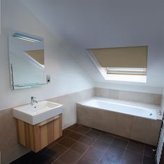 a bathroom with a sink, mirror and bathtub in it's corner area