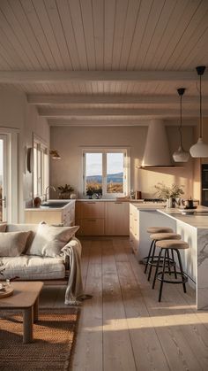 a living room filled with furniture next to a kitchen and an open floor plan on top of a hard wood floor