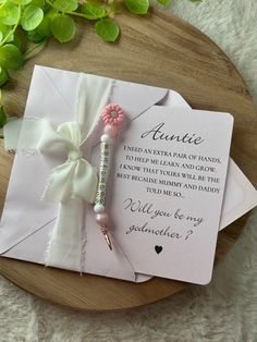 an envelope with a pink flower and ribbon attached to it