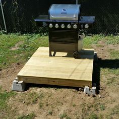 a grill sitting on top of a wooden platform