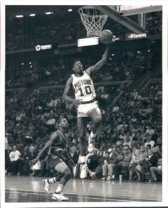 an old black and white photo of a basketball player dunking the ball into the hoop