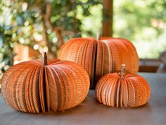 three orange pumpkins sitting on top of a table