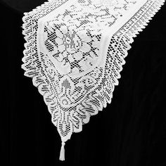 a white lace table runner on a black background