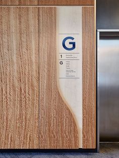 a stainless steel refrigerator next to a wooden wall