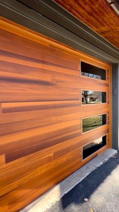 a wooden garage door with windows on the side