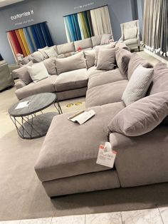 a large sectional couch in a store with lots of pillows