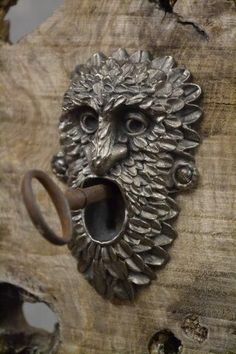 an animal head is mounted on the side of a piece of wood with a ring in it