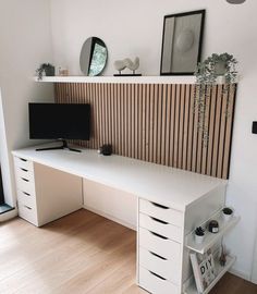 a white desk sitting next to a window in a room with wooden paneling on the wall