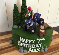 a birthday cake with a person on a toy atv