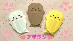 three origami cats are sitting next to each other on a pink and white background