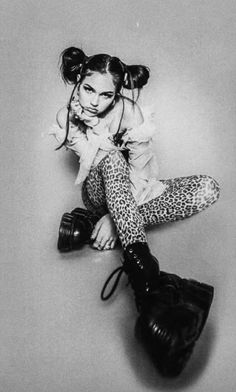 black and white photograph of a woman in leopard print leggings sitting on the ground