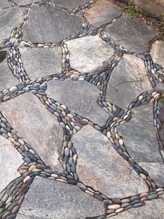 a close up of a stone walkway with rocks and stones in the middle, as well as an interlocked design