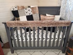 a baby crib with some pillows on top of it and a blanket in the middle