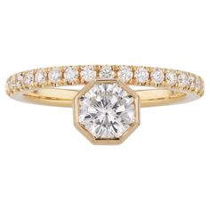 a yellow gold engagement ring with a round cut diamond in the center and two rows of diamonds on each band