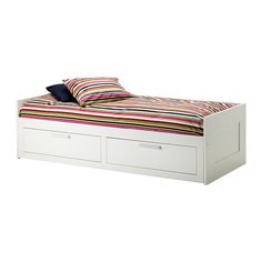 a bed with two drawers underneath it and a striped blanket on top of the bed