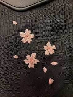 some pink flowers on the back of a black suitcase