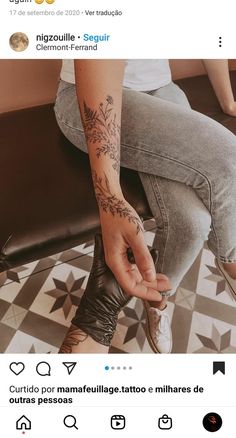 a person sitting on top of a bench with tattoos on their arm and foot,