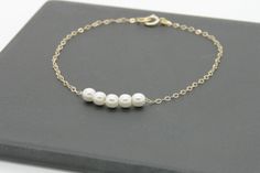 "Looks great dressy or casual, alone or layered with other bracelets.Classic bracelet. Five tiny white pearls adorn a 14k gold filled chain. 5 tiny freshwater white pearls 6mm Bracelet Length: 6\", 6.5\", 7\" ♥Shipping♥✈ It will take approx. 3-5 business das to US, and 1 - 2 weeks to all of the countries. All orders would be shipped it out within 1 to 2business days. ♥GREETINGS♥ If you are buying gifts for someone and have them mailed to the person directly, we are always happy to add a personal Elegant Tiny Pearl Jewelry, White Dainty Bracelet With Delicate Chain, Everyday White Pearl Bracelet With Delicate Chain, White Dainty Pearl Bracelet With Adjustable Chain, Dainty White Pearl Bracelet With Adjustable Chain, White 14k Gold-filled Bracelets With Pearl Chain, Everyday White Pearl Bracelet With Adjustable Chain, White 14k Gold Filled Pearl Chain Bracelets, White Pearl Chain Bracelet In 14k Gold Filled