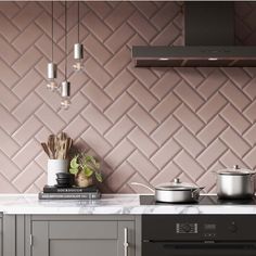 a stove top oven sitting inside of a kitchen next to a wall covered in tiles