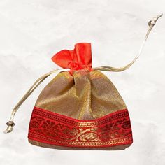 a red and gold bag with an orange ribbon tied to the side on a white background