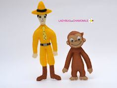 two stuffed monkeys dressed in yellow clothes and hats are standing next to each other on a white background