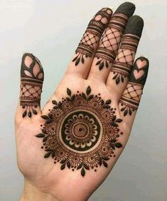 a hand with henna tattoos on it and two fingers in the shape of a circle