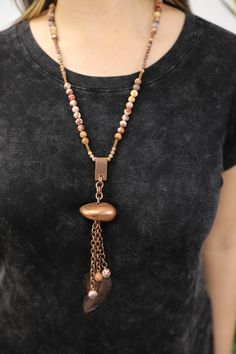 Our Fortuna necklace is a fantastic piece for the lover of vintage or nature inspired jewelry. This handmade necklace combines matte birdseye rhyolite stone beads, vintage elements, and bronze cable chain. From the rhyolite bead necklace hangs a tassel of chain and beads, a vintage stone-like pendant and a vintage feather charm. It is named for Fortuna, the goddess of fortune. A matching bracelet is available. Features: - Vintage Elements - Matte Birdseye Rhyolite - Cable Chain in Bronze - Leath Bohemian Brown Electroformed Necklaces, Bronze Necklaces With Natural Stones, Bronze Metal Necklaces With Natural Stones, Bronze Metal Necklace With Natural Stones, Bohemian Beaded Chain Copper Necklaces, Bohemian Copper Beaded Chain Necklaces, Bohemian Copper Necklace With Beaded Chain, Earthy Copper Pendant Necklace, Bohemian Bronze Beaded Chain Necklace