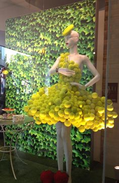 a mannequin dressed in a yellow dress made out of grapes and lemons