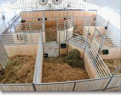 the inside of a barn with hay and two bikes in it's stall area