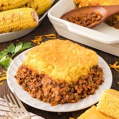 corn on the cob and ground beef casserole are sitting on a white plate