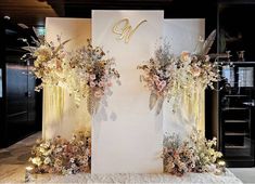 a white backdrop with flowers and candles on it